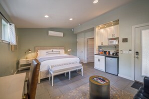 A bedroom with a bed, bedside tables, a bench, and a small table with magazines. - The Entrada #1 at Westside Flats - Downtown Moab (Moab)