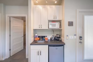 A compact kitchen with white cabinets, a microwave, a sink, and a dishwasher. - The Entrada #1 at Westside Flats - Downtown Moab (Moab)