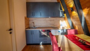 A compact kitchen with grey cabinets, a wooden countertop, and a red chair. - Velvet Retreat The Golden Cabins With Garden (Gjinar)
