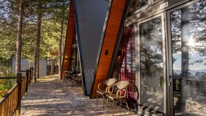 A wooden cabin with a glass door, surrounded by trees. - Velvet Retreat The Golden Cabins With Garden (Gjinar)
