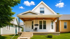A two-story house with a front porch, a small front yard, and a visible staircase leading to the entrance.