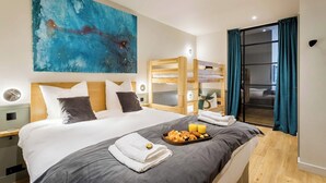 A hotel room with a large bed, a painting on the wall, a tray of breakfast items, and a sliding door with curtains. - Place des Vosges, Apartment With Air Conditioning (Paris)