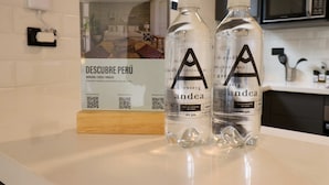 Two water bottles with labels on a counter, a QR code, and a sign with text and QR codes. - w Engaging Loft in the Heart of San Isidro (Lima)