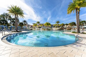 A swimming pool with palm trees and lounge chairs, surrounded by buildings. - Upstay Solara Resort Villa Pool Cinema Games (Kissimmee)