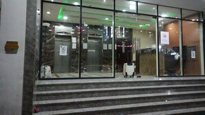 A hotel entrance with a glass facade, a set of marble steps, and a visible elevator. - Contemporary Partition Room in Tecom  (Dubai)