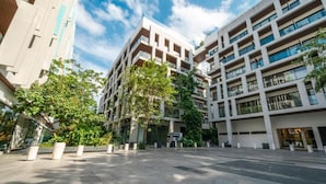 Een modern meerlaags gebouw met een binnentuin, met balkons en grote ramen.