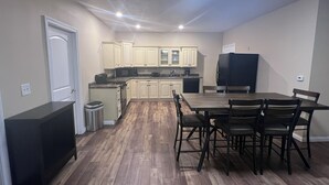 A compact kitchen with wooden flooring, a dining table with chairs, and a refrigerator. - Rathbun Lake, 1.5 miles from the Lake, 2-bdrm, 2 bath sleeps 7 in Rathbun, Iowa (Rathbun)