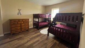 A bedroom with two bunk beds, a wooden dresser, and a ceiling light. - Rathbun Lake, 1.5 miles from the Lake, 2-bdrm, 2 bath sleeps 7 in Rathbun, Iowa (Rathbun)