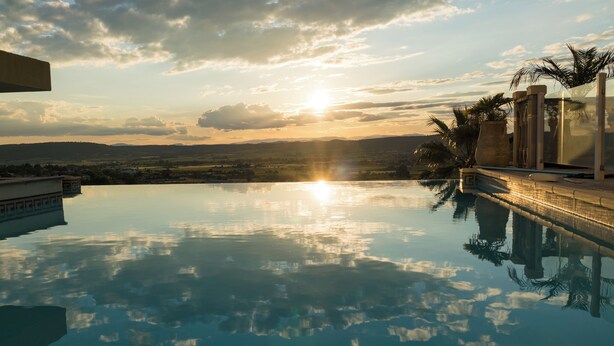 An infinity pool with a view of the sunset over a landscape. - L'Eden Bleu in Langlade, upscale romantic suite with private SPA. (Langlade)