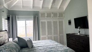 A bedroom with a bed, a dresser, a ceiling fan, and a TV. - The Crest - Serenity Oasis Villa (St. Ann's Bay)