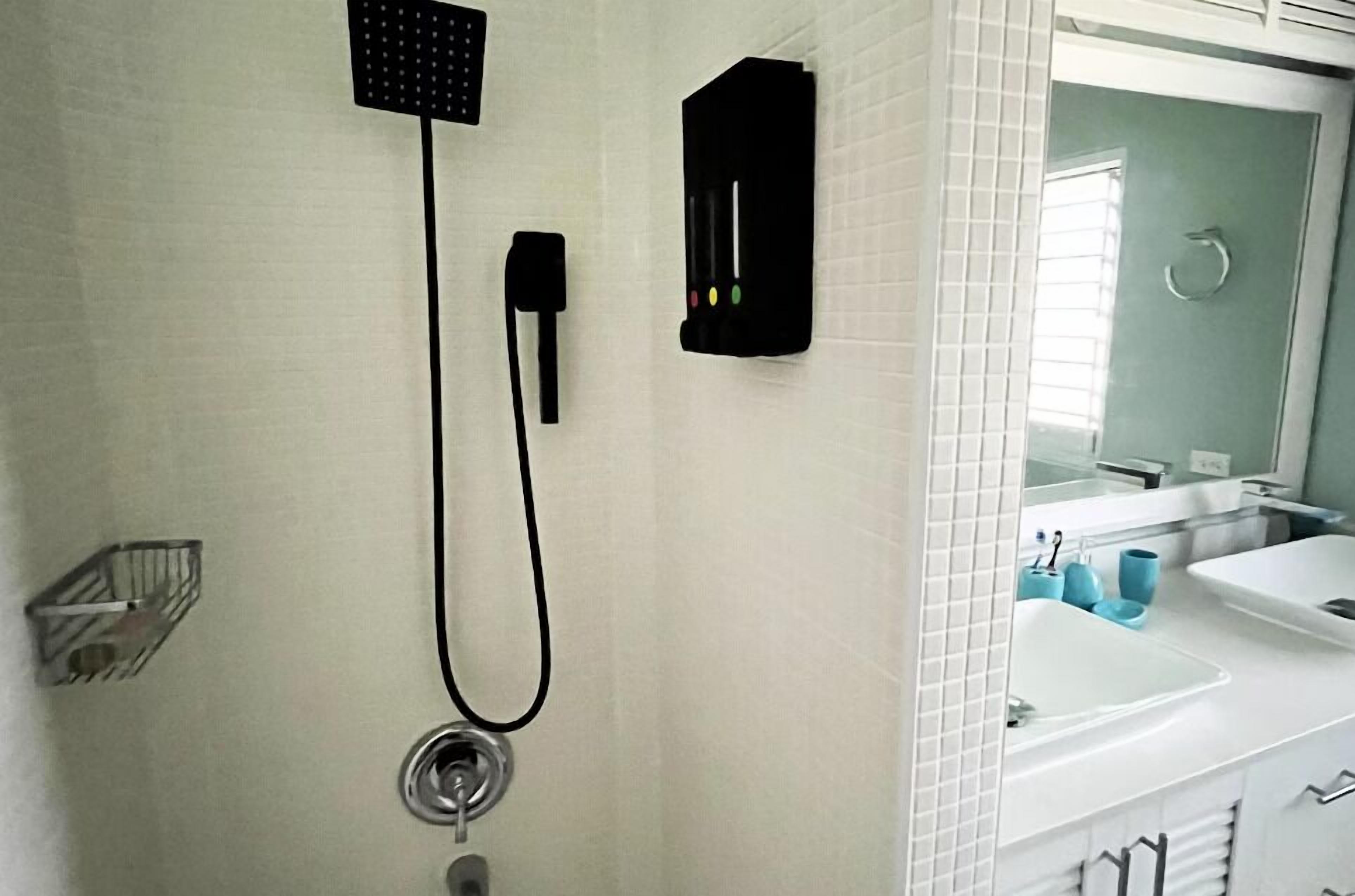 A bathroom with a shower, a sink, and a mirror.