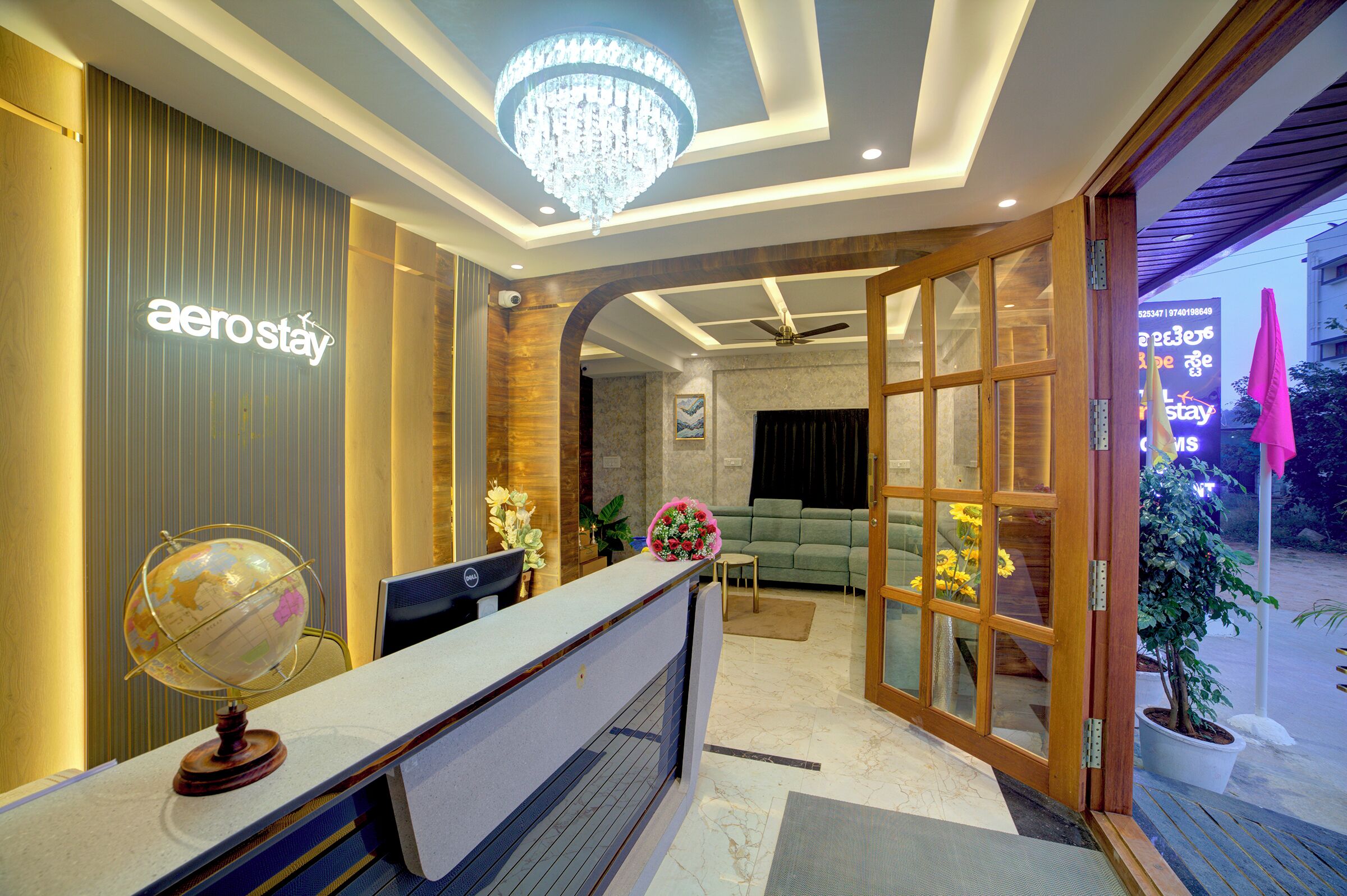 A reception area with a globe, a desk, and a chandelier.