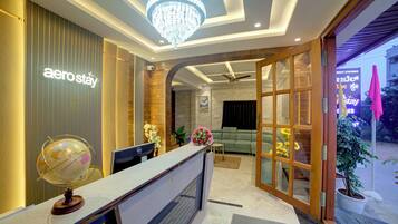 A reception area with a globe, a desk, and a chandelier.