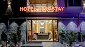 A hotel entrance with a reception desk, potted plants, and a sign reading "HOTEL AEROSTAY". - Hotel AeroStay Bangalore Airport (Bangalore)