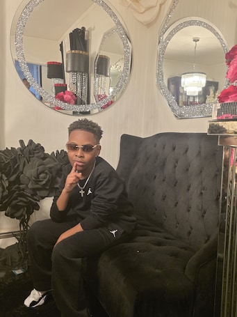 A person seated on a tufted black sofa in a room with two large, ornate mirrors and a chandelier.. Newly renovated 6-bedroom 2bath single family house.