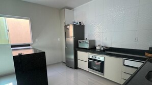 Una cocina moderna con refrigerador, horno, microondas y una encimera negra.