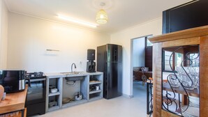 A compact kitchen with a built-in sink, a black refrigerator, and a coffee machine. - Well-located Condominium in Campinhos in Maraú - RVEs (Maraú)
