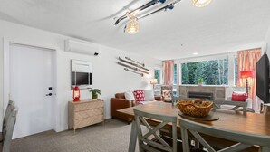 Un salon chaleureux avec une cheminée, une table à manger et un canapé.