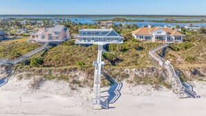 Um imóvel costeiro com várias casas, um caminho de acesso à praia e vista para o oceano.