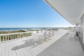 A white deck with a table and chairs, overlooking the ocean. - Seaside Splendor, The pinnacle of luxury. Brand New Oceanfront Rental (Saint Augustine)