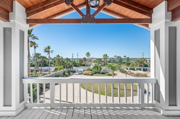 A covered porch with a view of a residential area, palm trees, and a clear sky. - Seaside Splendor, The pinnacle of luxury. Brand New Oceanfront Rental (Saint Augustine)