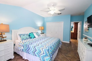 A bedroom with a bed, nightstands, a ceiling fan, and a TV. - Wonderful 3/2 close to beach! Heated pool! (Holmes Beach)