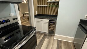 Une cuisine moderne dotée d’appareils électroménagers en acier inoxydable, de planchers en bois et d’une cave à vin intégrée.