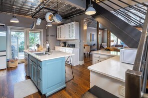 A modern kitchen with white and blue cabinetry, a central island, and a staircase leading to an upper level. - Your Luxury Private Telluride Getaway – Steps from Main Street & the Gondola (Telluride)
