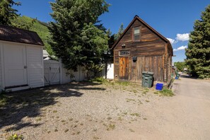 Ein rustikales Holzhaus mit einem Schotterweg und einer weißen Garage.