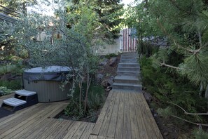 A wooden deck leading to a hot tub, surrounded by greenery and a wooden fence. - Your Luxury Private Telluride Getaway – Steps from Main Street & the Gondola (Telluride)