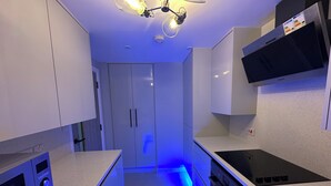 Une cuisine moderne avec des armoires blanches, une cuisinière noire et un four encastré.