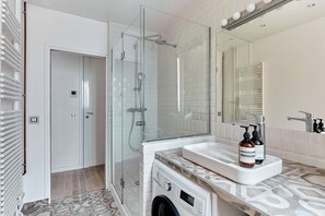 Appartement | Badkamer | Een haardroger, handdoeken, zeep, shampoo