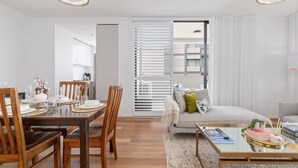 Een moderne woonkamer met een eethoek, een bank en een salontafel.