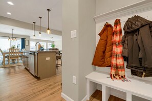 A modern kitchen with wooden flooring, pendant lighting, and a dining area with a table and chairs. - Luxury 3‑BR townhome • Penn State • Sleeps 11 • EV Level 2 • State College (State College)