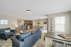 A modern living room with a sofa, coffee table, and dining area. - Luxury 3‑BR townhome • Penn State • Sleeps 11 • EV Level 2 • State College (State College)