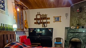 A bedroom with a large bed, a wooden ceiling, a fireplace, and a television. - Wine Vanult Apartment Tbilisi (T'bilisi)