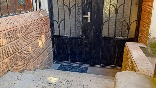A gated entrance with a metal gate and a small step leading up to a door. - Wine Vanult Apartment Tbilisi (T'bilisi)