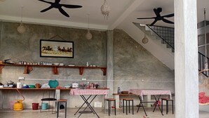 A spacious living area with a kitchen, dining table, and potted plants. - Light villa galle (Galle)