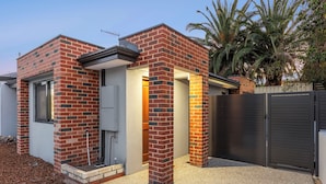 A modern house with a brick exterior, a garage door, and a palm tree in the background. - Premium Modern Homestay-Walk to Curtin University (Saint James)