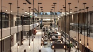 Een ruime atrium met hangende hanglampen, zitgedeeltes en een centrale trap.