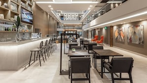 Ein modernes Interieur mit Barbereich, Sitzgelegenheiten und Kunstwerken an den Wänden.