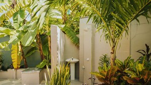 Un baño con piso de cuadros, un lavamanos y una ducha.