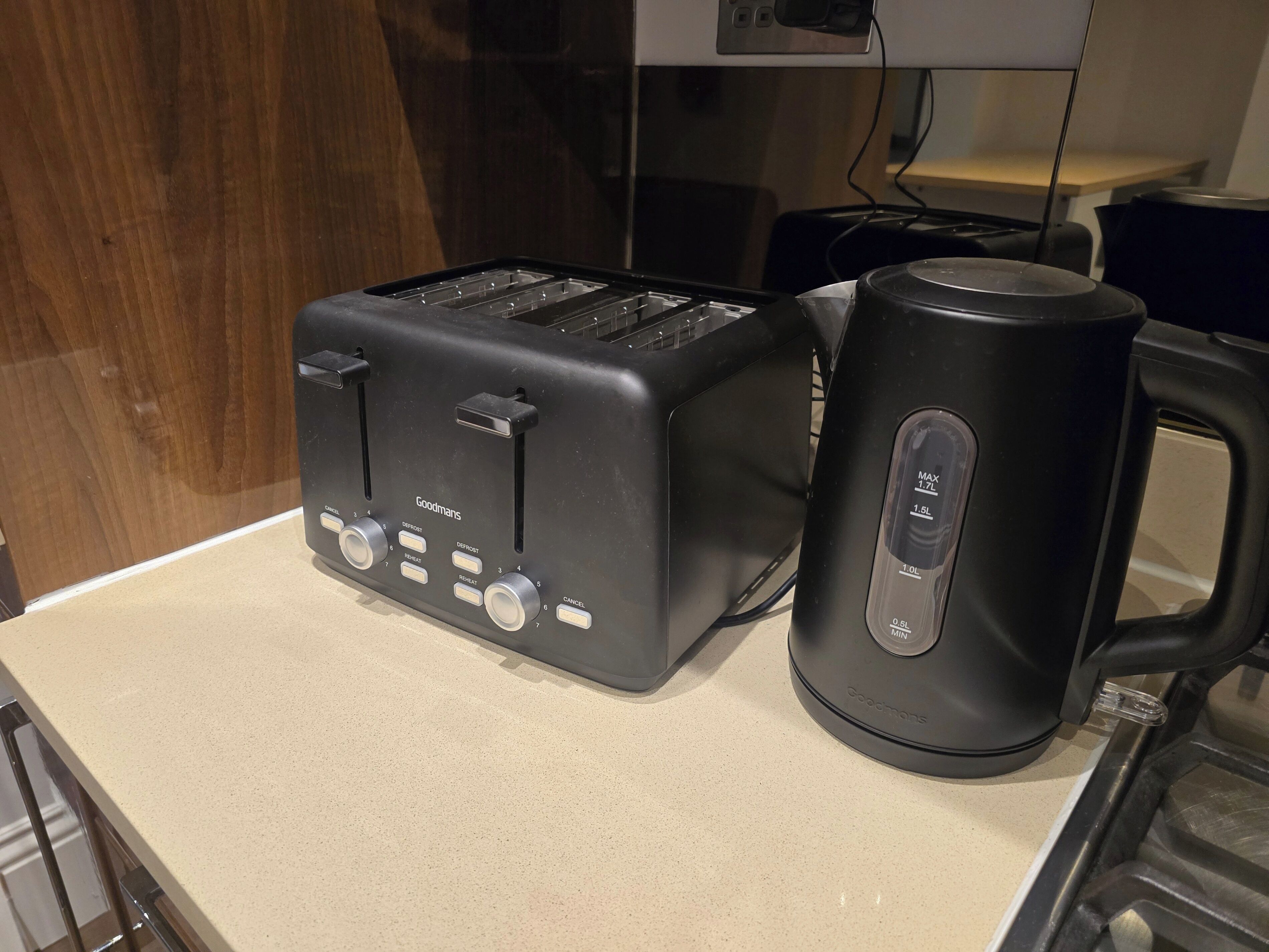 A kitchen with a black toaster and a black coffee maker on a countertop.