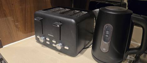 A kitchen with a black toaster and a black coffee maker on a countertop.