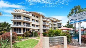 A multi-story hotel with balconies, a swimming pool, and a well-maintained garden. - Relaxing Getaway Steps Beach With Pool (Hervey Bay)