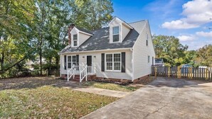 A single-story house with a front porch, a chimney, and a small front yard. - Midterm 3BR/2BA Rental near Pelham Rd Greenville SC (Greenville)