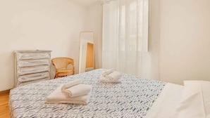 A bedroom with a bed, a dresser, a chair, and a mirror. - Welcome to Casa del Sale, a comfortable holiday apartment located right in the center of La Spezia – the perfect base to explore the wonders of the Cinque Terre and the Gulf of Poets.The apartment is cozy, well-kept, and equipped with everything you ne (La Spezia)