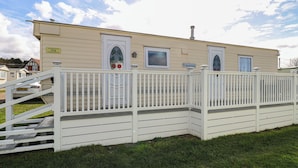 A single-story mobile home with a white exterior, a front porch, and a small staircase leading to the entrance.