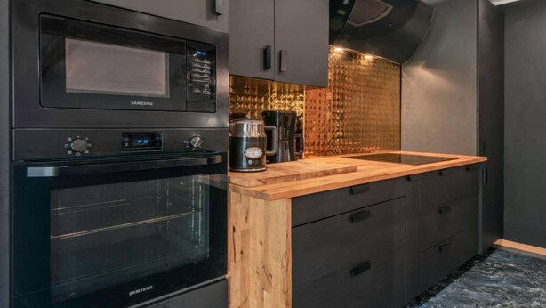 A modern kitchen with a built-in microwave, oven, and coffee maker. - Comfortable house with a swimming pool and sauna (Anielino)