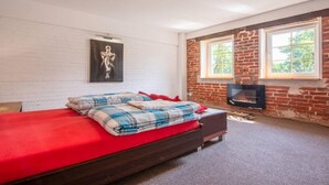 A bedroom with a bed, a fireplace, and a window. - Comfortable house with a swimming pool and sauna (Anielino)